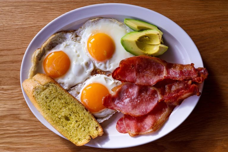 Talerz keto śniadania z jajkami sadzonymi, boczkiem i awokado